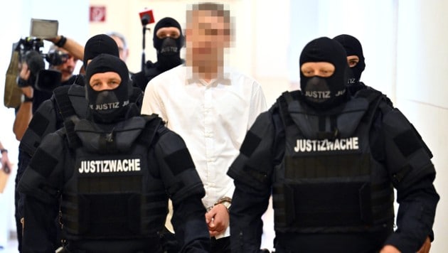 Der 18-jährige angeklagte Terrorverdächtige wird schwer bewacht vorgeführt.