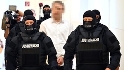 Der 18-jährige angeklagte Terrorverdächtige wird schwer bewacht vorgeführt.