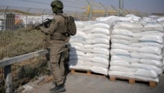 Ein israelischer Soldat bewacht Hilfsgüter, die auf ihre Übernahme warten.