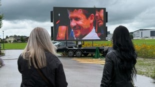 Auf einer Videoleinwand vor der Trauerhalle werden Szenen aus Baumgartners Leben gezeigt.