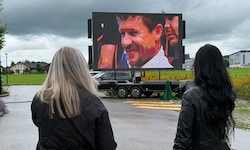 Auf einer Videoleinwand vor der Trauerhalle werden Szenen aus Baumgartners Leben gezeigt.