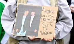 Eine Demonstrantin hält ein Plakat, auf dem Epstein und Trump abgebildet sind.