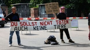 Demonstranten stehen mit Protestschildern vor dem Tiergarten Nürnberg.