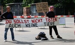 Demonstranten stehen mit Protestschildern vor dem Tiergarten Nürnberg.