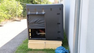 Toni A. schläft hier in seiner aus Holz und schwarzen Planen selbst gebauten Behausung. 