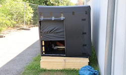 Toni A. schläft hier in seiner aus Holz und schwarzen Planen selbst gebauten Behausung. 
