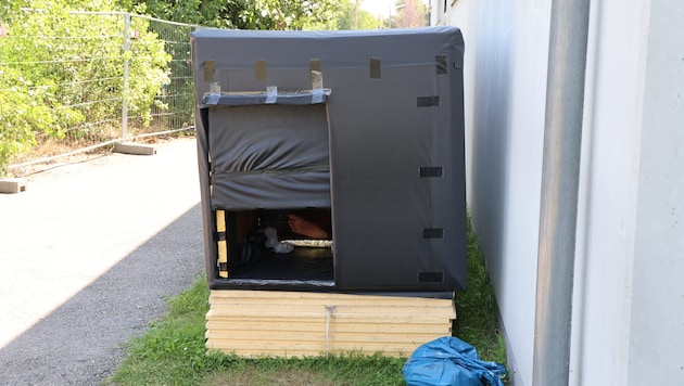 Toni A. schläft hier in seiner aus Holz und schwarzen Planen selbst gebauten Behausung.