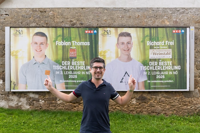 Lehrlingswart David Rößl vor den ersten Landessieger-Plakaten.