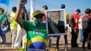 Mit einem Porträt von Präsident Lula in der Hand protestiert ein Brasilianer gegen Trumps Zölle.