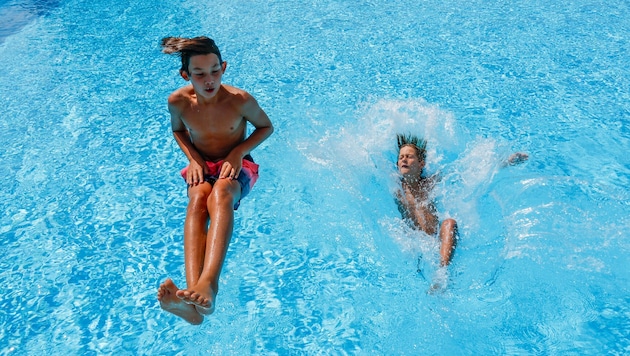 Julian und Robin genießen in Anthering den Sprung ins kühle Nass. Salzburgs Bäder haben aktuell ...