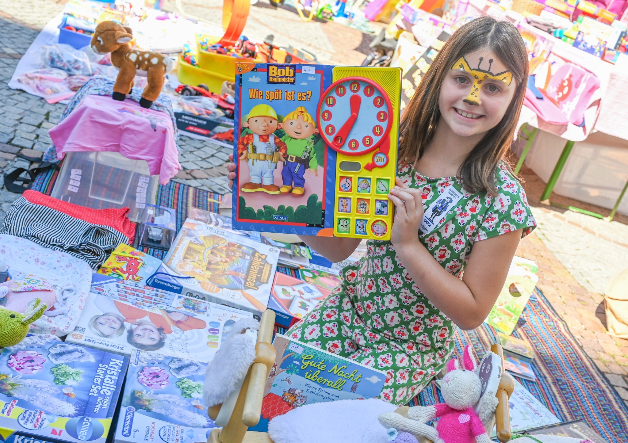 Malina trennt sich am Flohmarkt von Spielsachen.