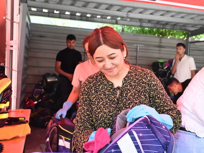 Viele fleißige Hände befüllen die Schultaschen und -rücksäcke.