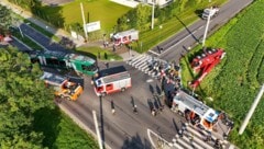 Der Bergekran (re.) war über eine Böschung gestürzt und hatte zwei Feuerwehrleute eingeklemmt.