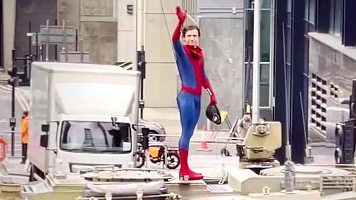 Tom Holland winkt während er Dreharbeiten in Glasgow in seinem neuen Spider-Man-Anzug den Fans.