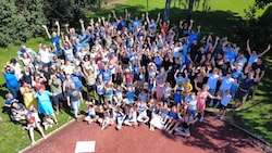 Beim musikalischen Start in den Tag auf dem Sportplatz singen, klatschen und schwingen alle 140 ...