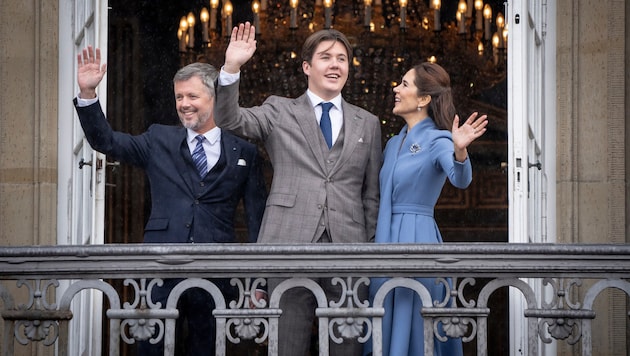 Kronprinz Christian (Mitte) winkt mit seinen Eltern, König Frederik und Königin Mary, vom Balkon ...