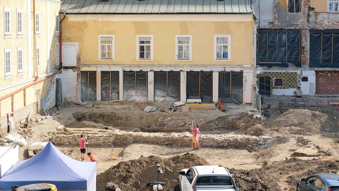 Hinter dem Schauspielhaus wird archäologisch gegraben; der Steinwall in der Mitte ist ein Kanal ...