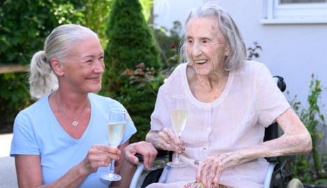 Pflegerin Doreen Leitinger stößt mit der 104-jährigen Irmgard Perfahl an.