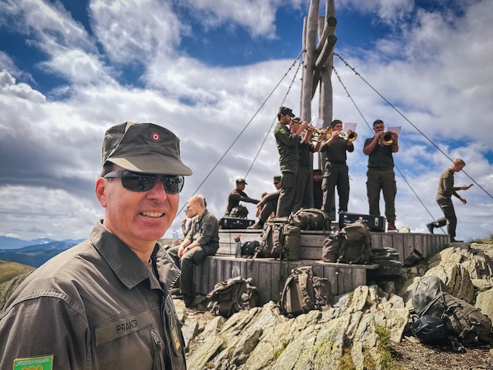 Kommandant Dietmar Pranter mit den spielenden Musikern im Hintergrund.