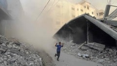Ein palästinensischer Bub flieht vor israelischen Luftschlägen im nördlichen Gazastreifen.