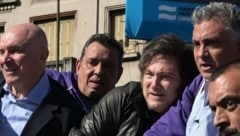 Argentiniens Präsident Javier Milei (Mitte) ist bei einer Veranstaltung mit Steinen beworfen ...