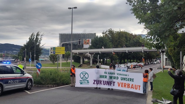 Der Protest sorgt bereits für Chaos im Frühverkehr – an der Brücke haben sich zwei Aktivisten ...