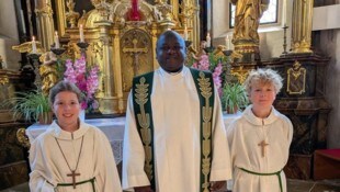 Pfarrer Emmanuel Maigari mit den Ministranten Frida und Samuel bei seiner ersten Messe in ...