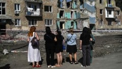 Anwohner begutachten bestürzt Zerstörungen nach russischen Luftangriffen auf Kiew.
