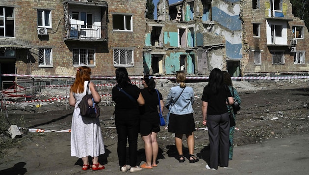 Anwohner begutachten bestürzt Zerstörungen nach russischen Luftangriffen auf Kiew.