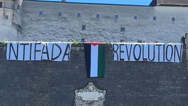Protestplakate und die Flagge Palästinas auf der Festung.