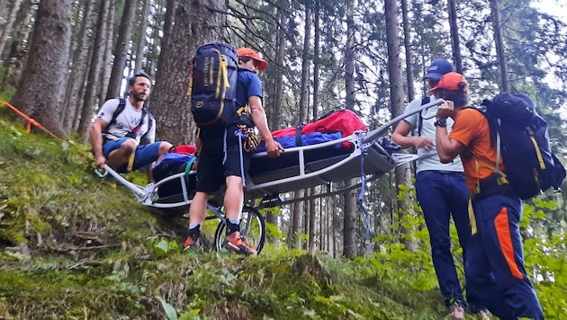 Bergretter tragen eine verletzte Wanderin über den Steinalmweg ins Tal.