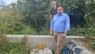 Stadtrat Thomas Haffer (ÖVP) bei den Sandsäcken, die den Wasserlauf absperren