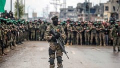 Bewaffnete Kämpfer der Hamas stehen Wache während der Übergabe von drei israelischen Geiseln.
