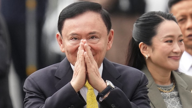 Ex-Premier Thaksin Shinawatra begrüßt seine Anhänger vor dem Sitz des Obersten Gerichtshofs in ...