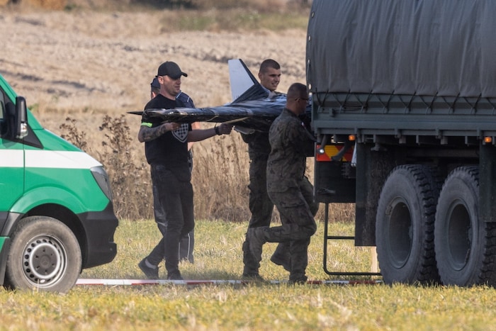 Ermittler laden eine Drohne in ein Militärfahrzeug.