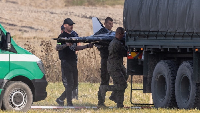 Ermittler laden eine Drohne in ein Militärfahrzeug.