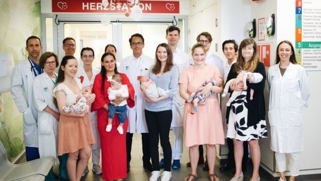 Dr. Zimpfer (Bildmitte) mit seinem Team und den glücklichen Müttern