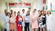 Dr. Zimpfer (Bildmitte) mit seinem Team und den glücklichen Müttern