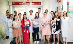 Dr. Zimpfer (Bildmitte) mit seinem Team und den glücklichen Müttern