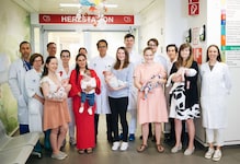 Dr. Zimpfer (Bildmitte) mit seinem Team und den glücklichen Müttern