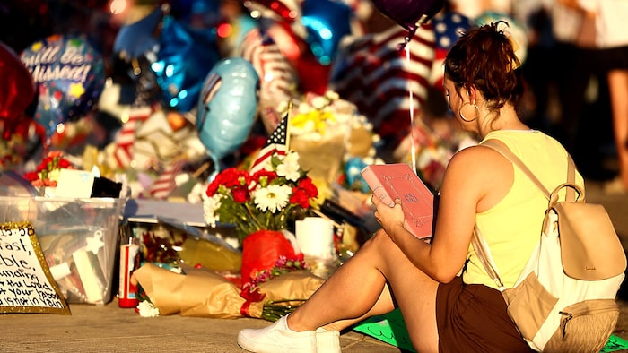 Eine junge Frau trauert mit einer Bibel um Charlie Kirk.