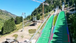 Knapp fünf Monate vor den Spielen wird im Skisprung-Stadion noch fleißig gebaut.
