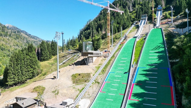 Knapp fünf Monate vor den Spielen wird im Skisprung-Stadion noch fleißig gebaut.