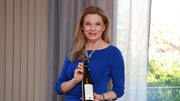 Die ehemalige Wetterlady posiert auch hier mit einem edlen Tropfen.