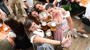 Dirndl, Selfie, erste Maß! Die jungen Damen stoßen stilecht an.