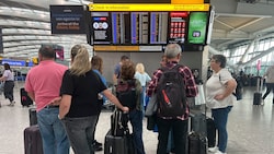 Passagiere informieren sich über die aktuelle Lage nach dem Cyberangriff auf ein ...