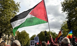 Ein Demonstrant schwingt bei einem Protest in Frankreich die palästinensische Flagge – Paris ...