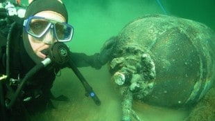 Ein Taucher mit einer Ankertaumine, die während des Krieges vor allem in der Nord- und Ostsee ...