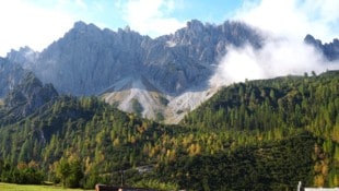 Wundervolle Felswände und Gipfel mit orange verfärbten Bäumen ragen hinter der Eppzirler Alm ...