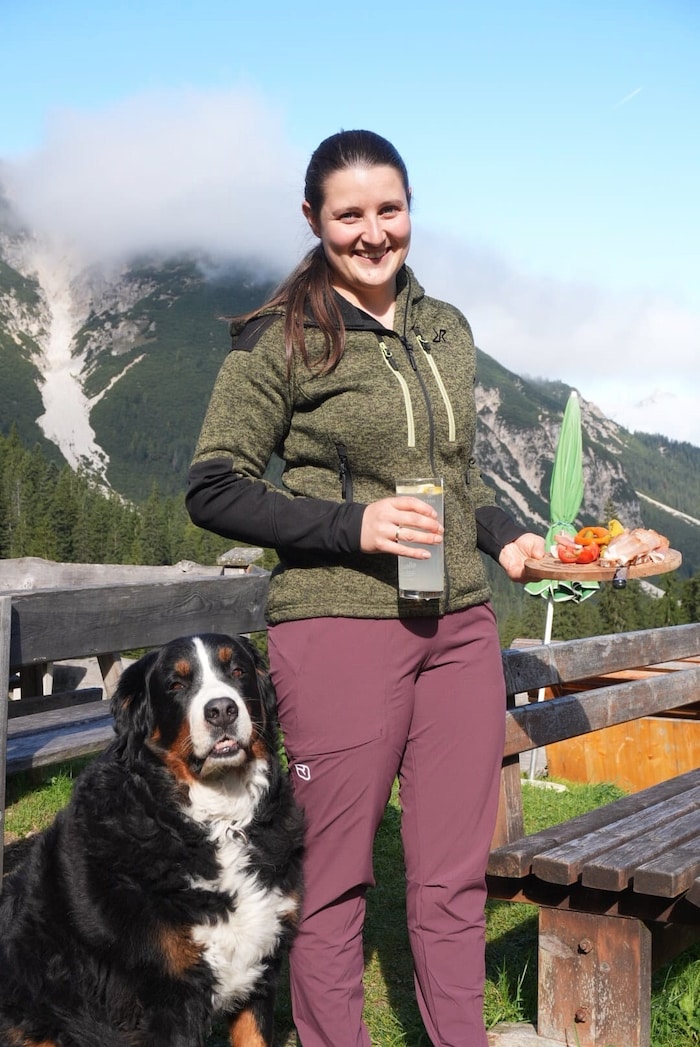„Almchefin“ Vanessa serviert Köstlichkeiten, Hütehund Joe assistiert.
